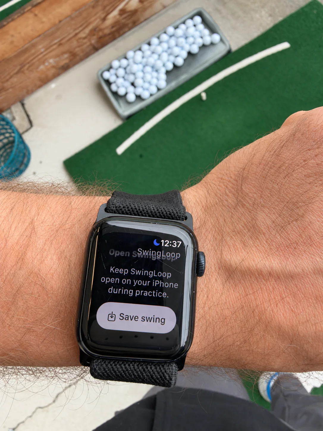 SwingLoop on an Apple Watch at the driving range, showing the Save swing button and a reminder to keep the paired iPhone app open